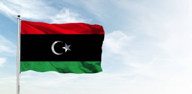 Mavi gökyüzünde Libya bayrağı. Yatay panoramik pankart.