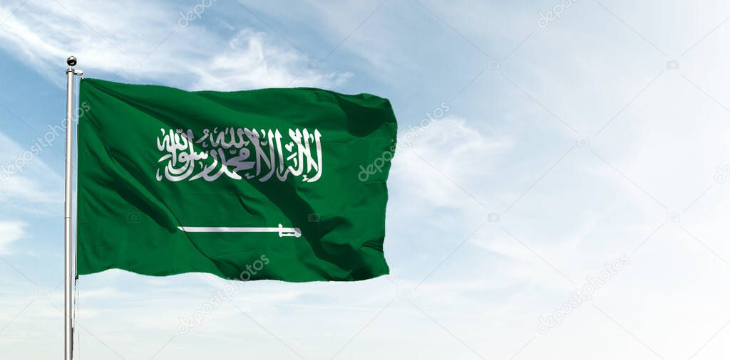 Saudi Arabia flag in the blue sky. Horizontal panoramic banner.