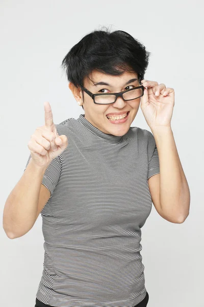 Retrato de una mujer sonriente señalando con el dedo hacia arriba — Foto de Stock