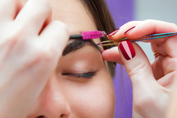 Correction of eyebrow tweezers, eyebrow henna painting, beautiful young girl beauty salon, plucking and simulation form a perfect eyebrows, tattoos and permanent make-up, soft focus — Stock Photo, Image