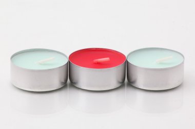 Beyaz bir rafa yanan mumlar