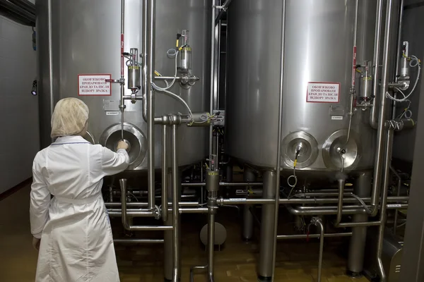 Travailleur effectue le contrôle de la qualité près du réservoir avec du lait — Photo