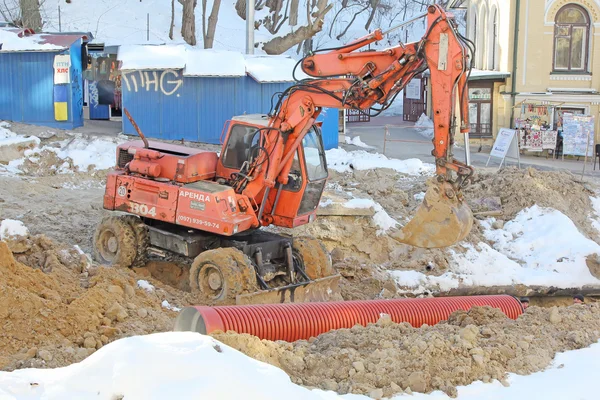 Kiev, UKRAINE - 17 February 2015: The roadway, excavator leads r Royalty Free Stock Photos