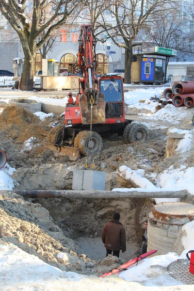 Kiev, UKRAINE - 17 February 2015: The roadway, excavator leads r Royalty Free Stock Photos