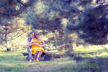 Mutlu ve genç hamile çift doğa üzerinde