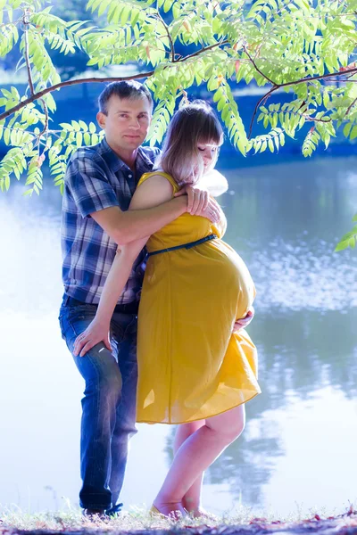 Joyeux et jeune couple enceinte sur la nature — Photo