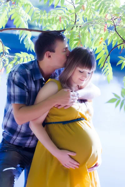 Glückliches und junges schwangeres Paar über die Natur — Stockfoto