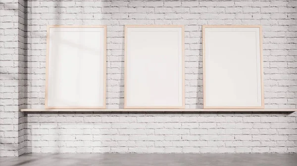 Rafta beyaz tuğla bir duvara karşı dizilmiş üç çerçeveli galeri tarzı bir maket. Markalaşma sistemleri, poster serileri, sanat koleksiyonları ve profesyonel iç sunumlar için ideal.