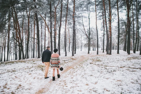 Bride and groom walking in winter forest — Stock Photo, Image