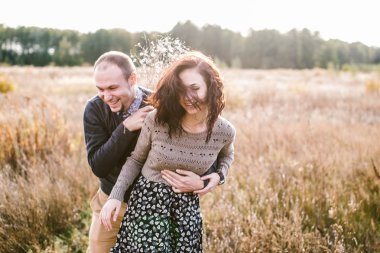 Genç çift günbatımında sarılma