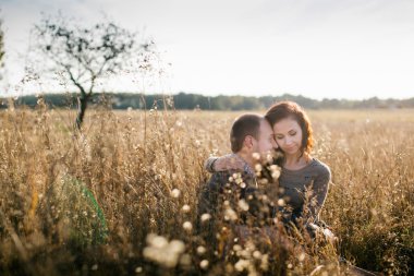 Genç çift günbatımında sarılma