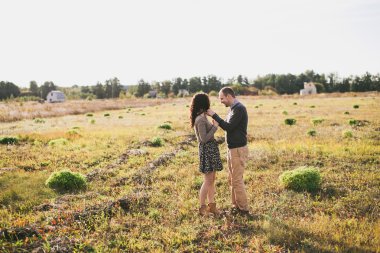 Genç çift günbatımında sarılma