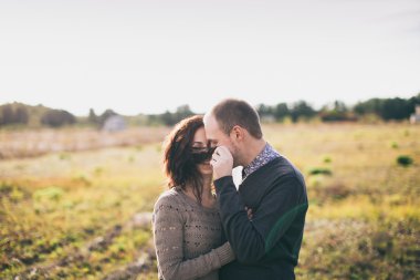 Genç çift günbatımında sarılma