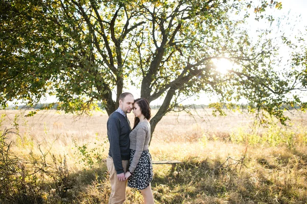 Young couple holding hands at autumn sunset — Stock Photo, Image