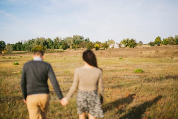 Jong koppel wandelingen bij zonsondergang hand in hand — Stockfoto