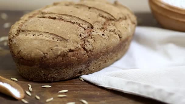 Pan de pan de centeno orgánico casero recién horneado sobre mesa de madera — Vídeos de Stock