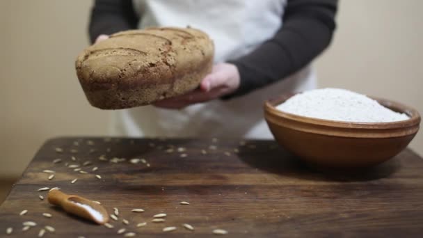 Baker, ήπια θέση πρόσφατα ψημένο καρβέλι ψωμιού σίκαλης σπιτικό οργανικό μεταλευτής κάτω στο ξύλινο τραπέζι — Αρχείο Βίντεο