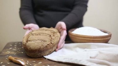 Ahşap masa üzerinde pişmiş aşağı yavaşça taze koyarak Baker ev yapımı organik Maya çavdar ekmek