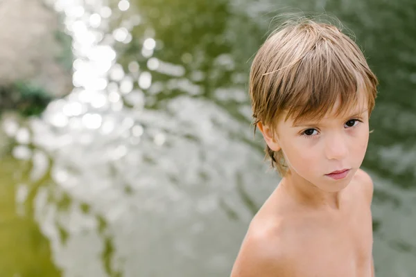 Carino bambino vicino all'acqua in spiaggia nella calda giornata estiva — Foto Stock