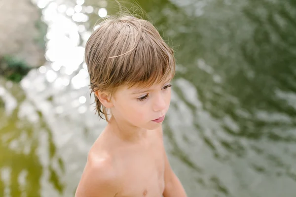 Carino bambino vicino all'acqua in spiaggia nella calda giornata estiva — Foto Stock