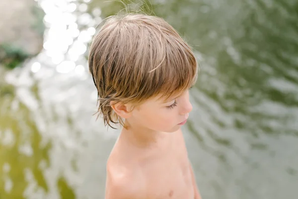 Carino bambino vicino all'acqua in spiaggia nella calda giornata estiva — Foto Stock