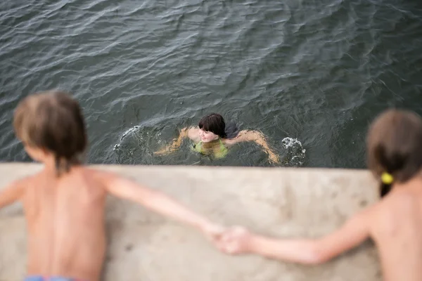 Sıcak yaz gününde göle ahşap güverte elele Çift yumurta ikizleri tan