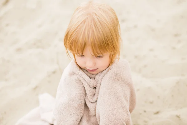 Ragazzina con i capelli rossi in un asciugamano in spiaggia — Foto Stock