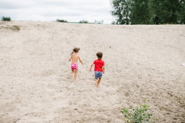 Plajda çıplak ayakla çalışan Çift yumurta ikizleri