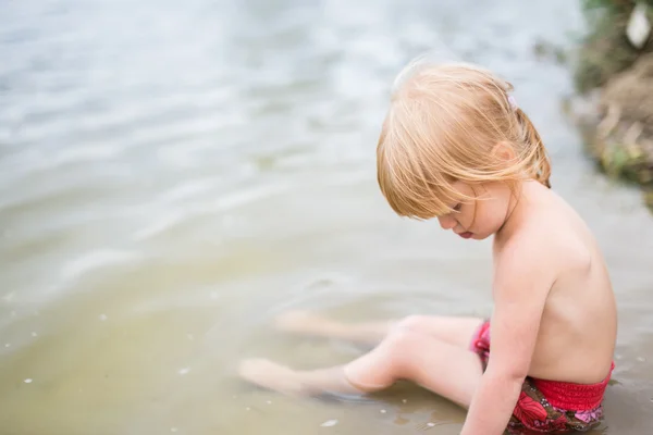 Cute toddler girl with red hair playing in water — Stock Photo, Image