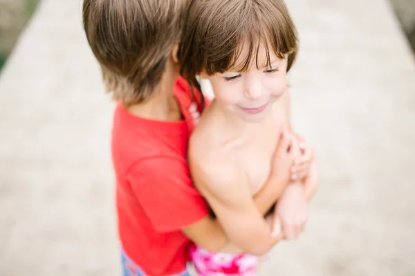 Fraternal twins hugging at the beach — Stock Photo, Image