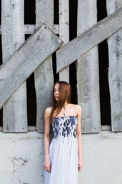 Terk edilmiş binada yakınındaki çiçek elbiseli kızıl saçlı genç bayan