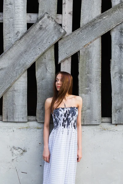 Kızıl saçlı genç kadın terk edilmiş binada yakınındaki çiçek elbise