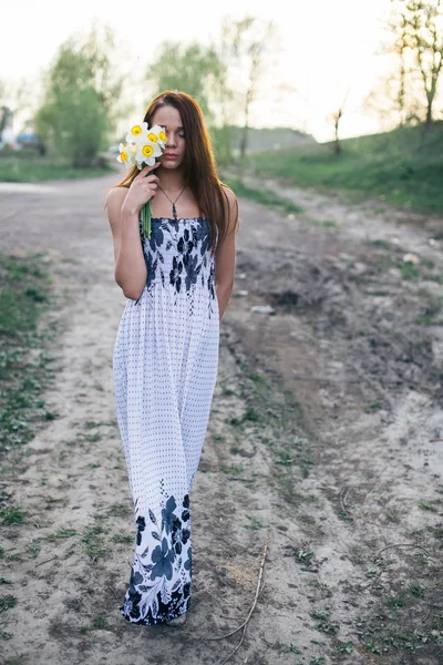 Red-haired young lady with bouquet of daffodils — Stock Photo, Image