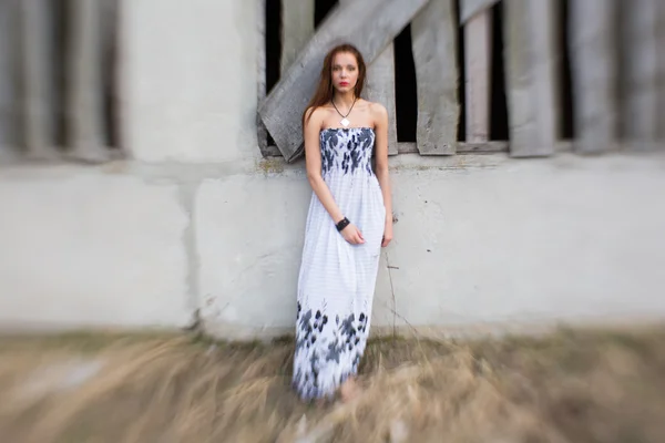 Red-haired young woman in floral dress near abandoned building — Stock Photo, Image