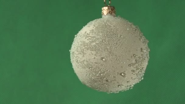 Bola de Navidad sobre un fondo verde — Vídeo de stock