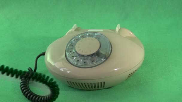 Old phone on a green background — Stock Video