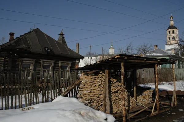Russisches Dorf, der Holzstapel und das Kloster im Hintergrund — Stockfoto