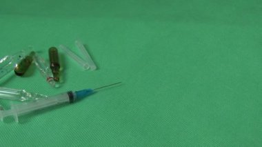 tıbbi şırınga ve şişeleri yeşil zemin üzerine