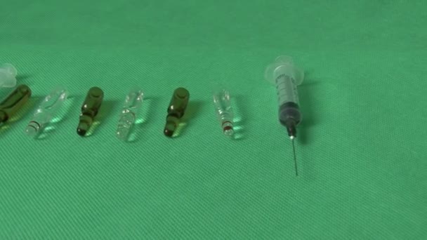 Медицинские шприцы и флаконы на зеленом фоне — стоковое видео