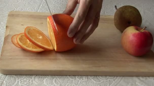 Cuchillo, naranja. Manos de mujer — Vídeo de stock