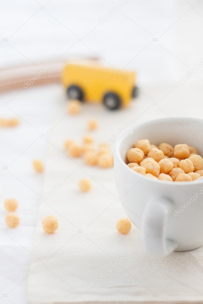white cup of yellow corn puffs 