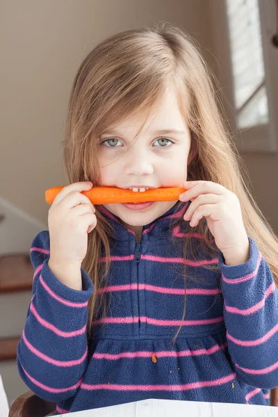 Niña mordiendo una zanahoria —  Fotos de Stock