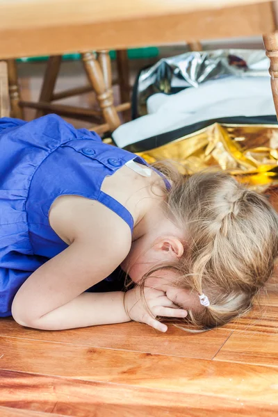 Little girl hiding under the table — Stock Photo, Image