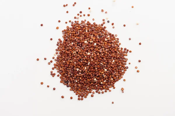 Röd quinoa spillde på vit bakgrund — Stockfoto