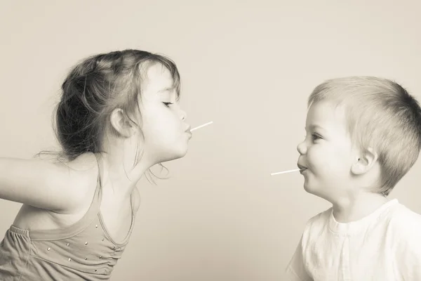 Siblings having fun with lollipops — Stock Photo, Image