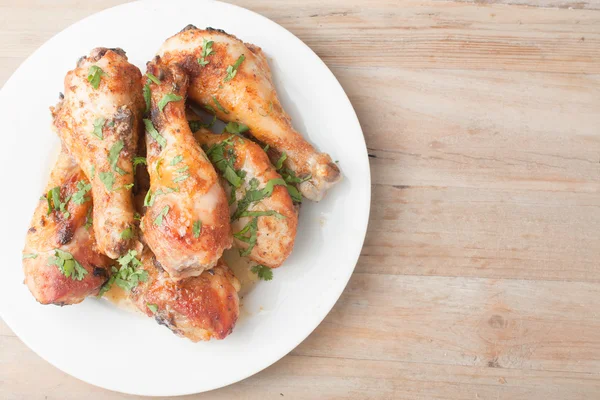 ahşap arka plan üzerinde taze tavuk budu ile plaka