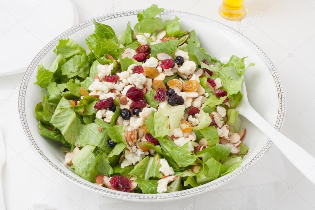 salad with gorgonzola cheese and dry berries in white bowl
