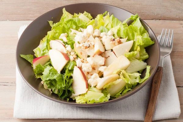 Salad with apples and walnuts on rustic wooden background — Stock Photo, Image