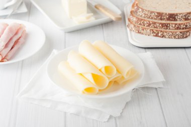 cheese rolled up on white plate clipart