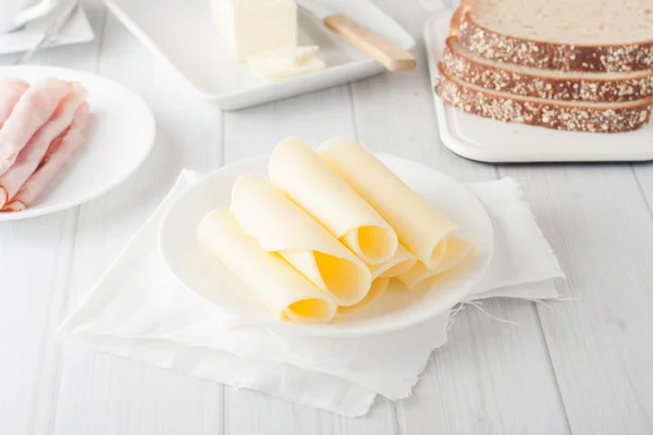 Käse eingerollt auf weißem Teller — Stockfoto